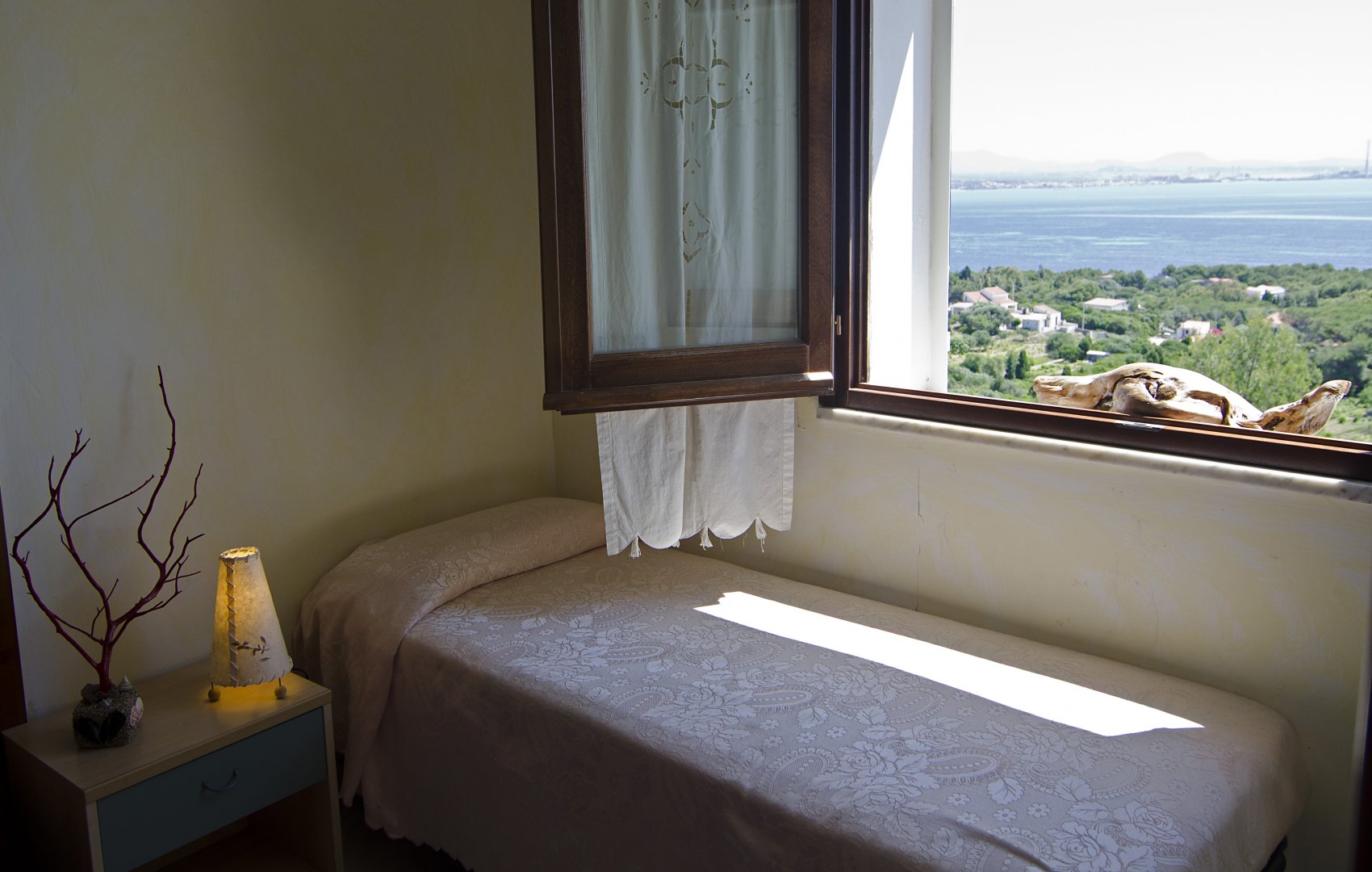 Dettaglio letto singolo in camera Hotel Paola con vista sul mare del Sulcis